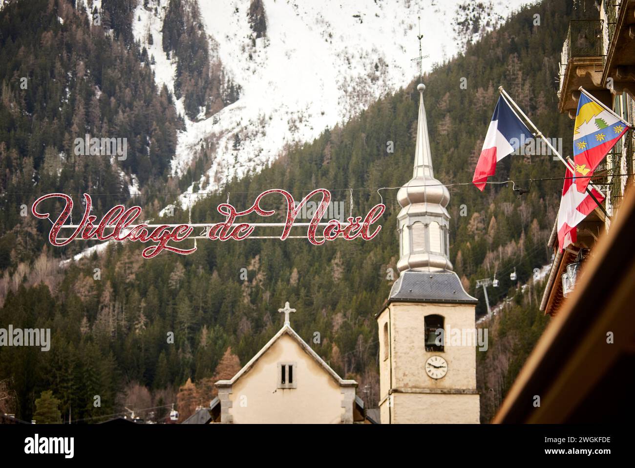 Chamonix Mont Blanc, Francia. Village de Neol chalet in legno, area del mercato di Natale incorniciata dalla chiesa di San Bernardo del Monte bianco di Paroisse Foto Stock