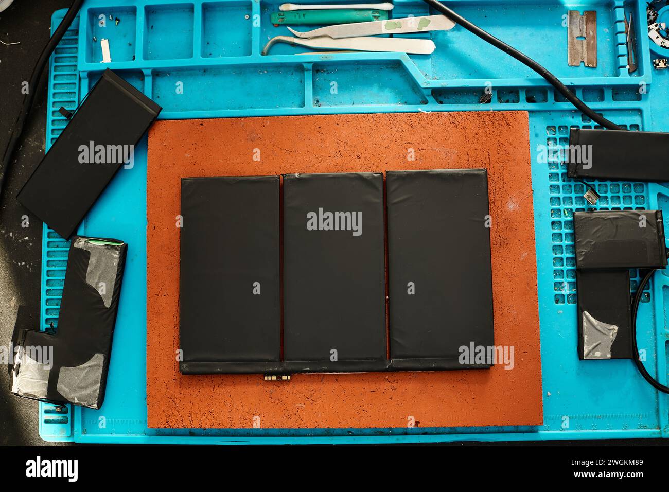 set di nuove batterie sulla scrivania nell'officina di manutenzione elettronica, concetto aziendale di riparazione Foto Stock