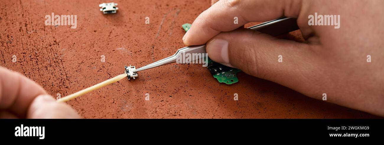 vista parziale del personale di riparazione professionale con microschema di test delle pinzette in un'officina privata, striscione Foto Stock