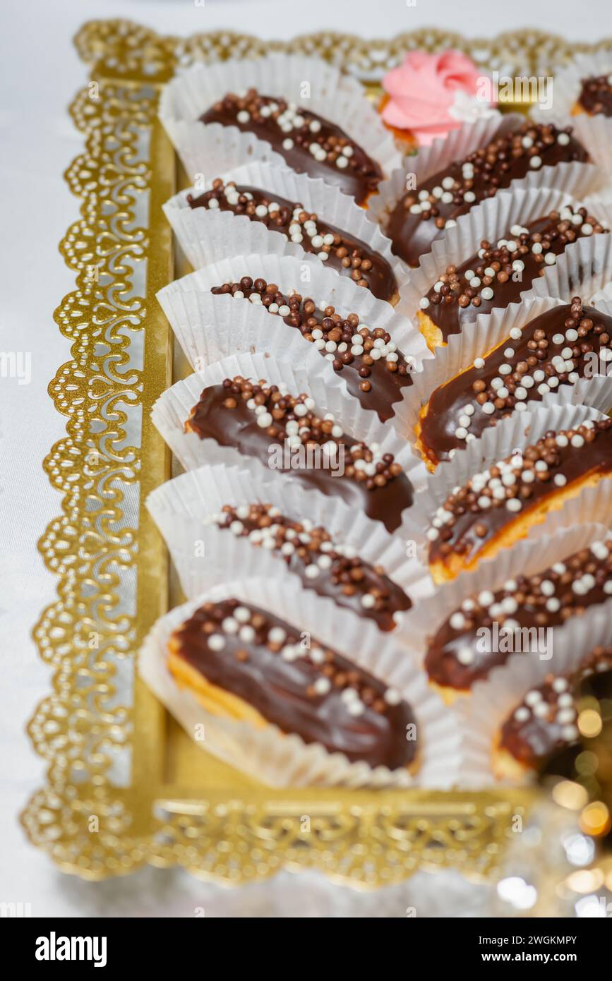 Piccoli eclari dolci a base di pasta sfoglia con coloratissime spruzzette primi piani di cibo per feste Foto Stock