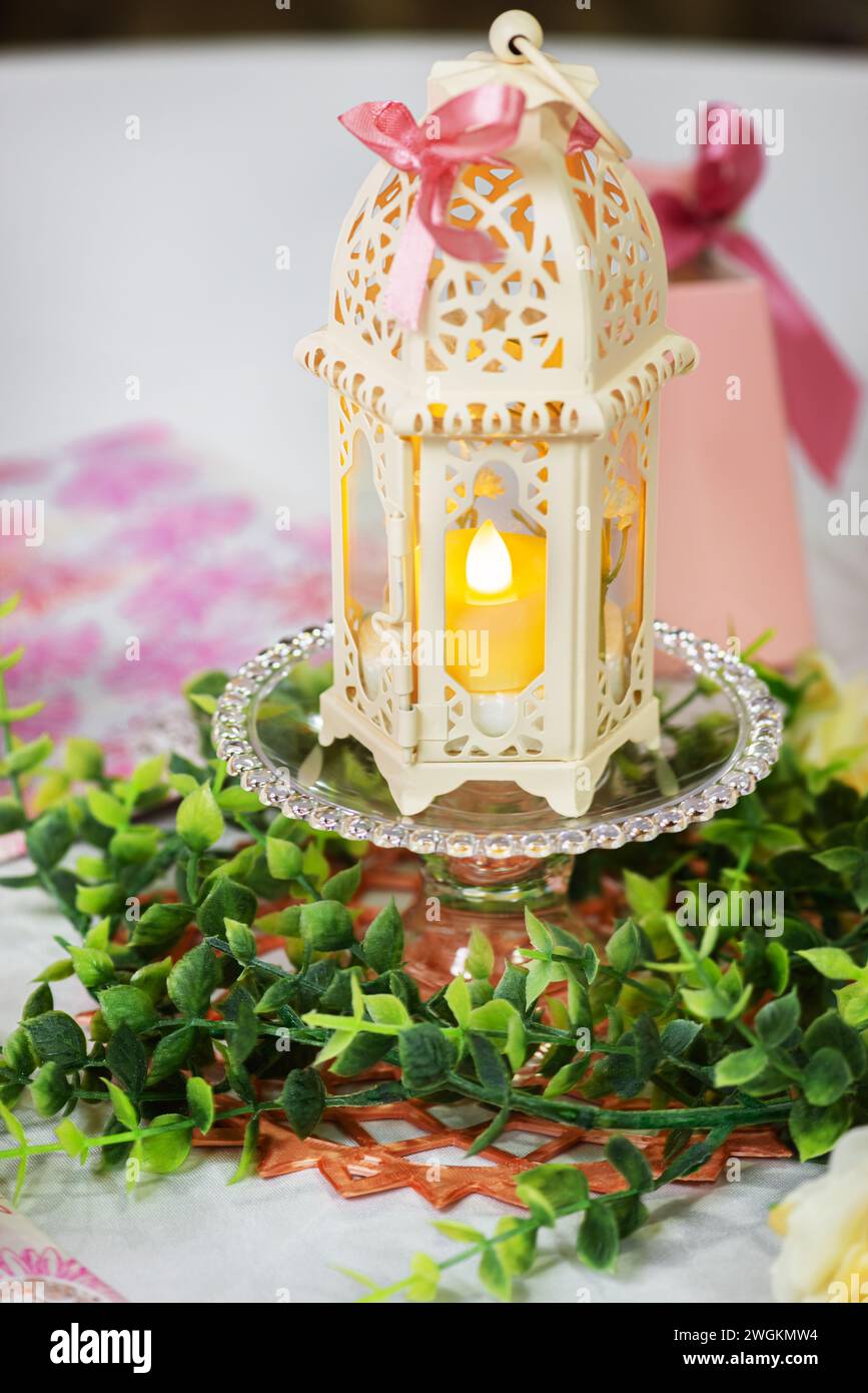 Semplice tavolo centrale a tema islamico carta lanterna e fogliame decorativo verde plastica Foto Stock