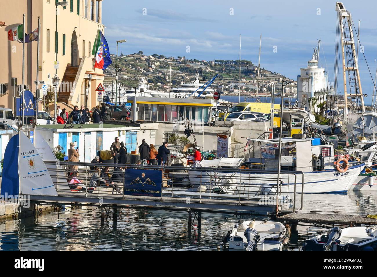 Persone in attesa in fila per acquistare pesce fritto da un negozio di frittura attraccato nel Porto Vecchio in una soleggiata giornata invernale, Sanremo, Imperia, Liguria, Italia Foto Stock