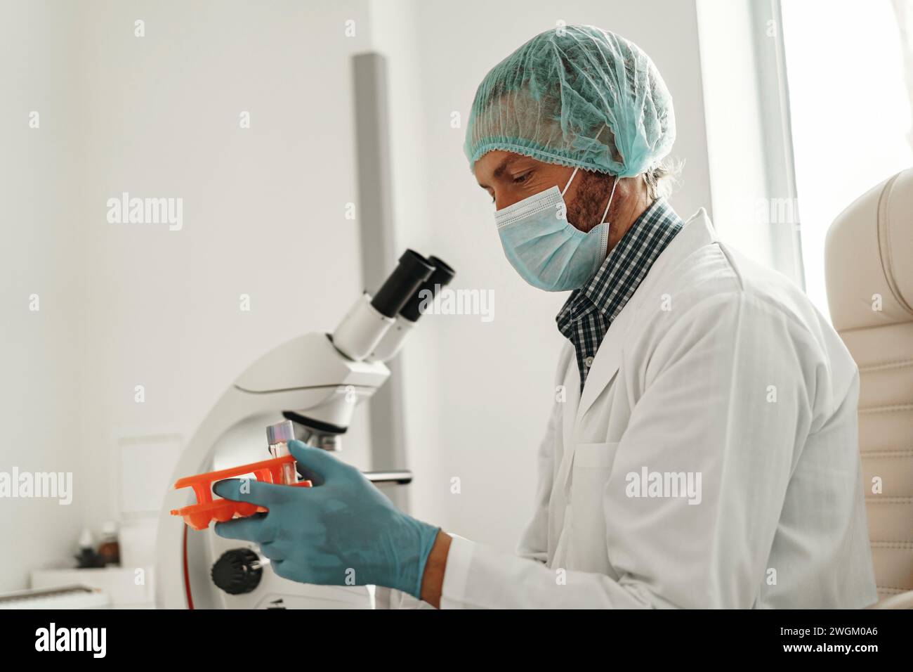 Scienziato della ricerca biochimica che lavora con il microscopio nella ricerca farmaceutica in laboratorio Foto Stock