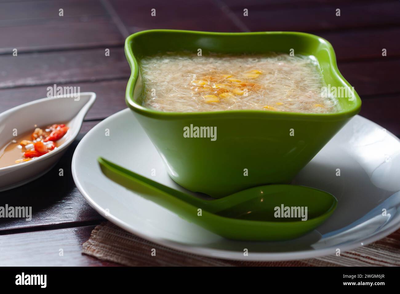 Zuppa di mais di pollo servita in una ciotola verde. Colazione calda adatta a temperature fredde Foto Stock