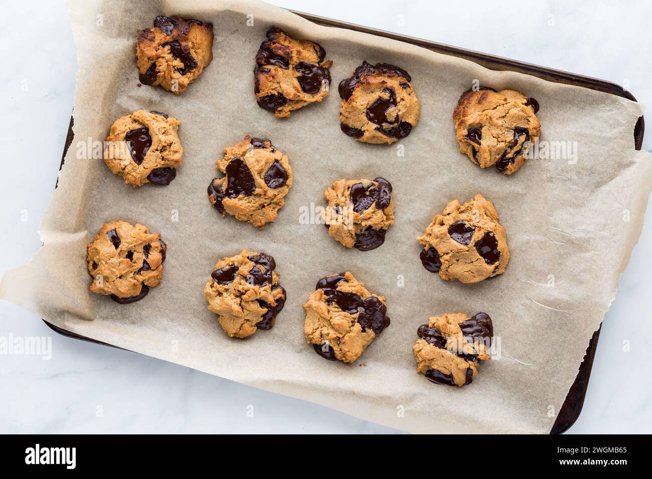 Biscotti a pezzi di cioccolato al burro di arachidi su una teglia rivestita in pergamena. Foto Stock