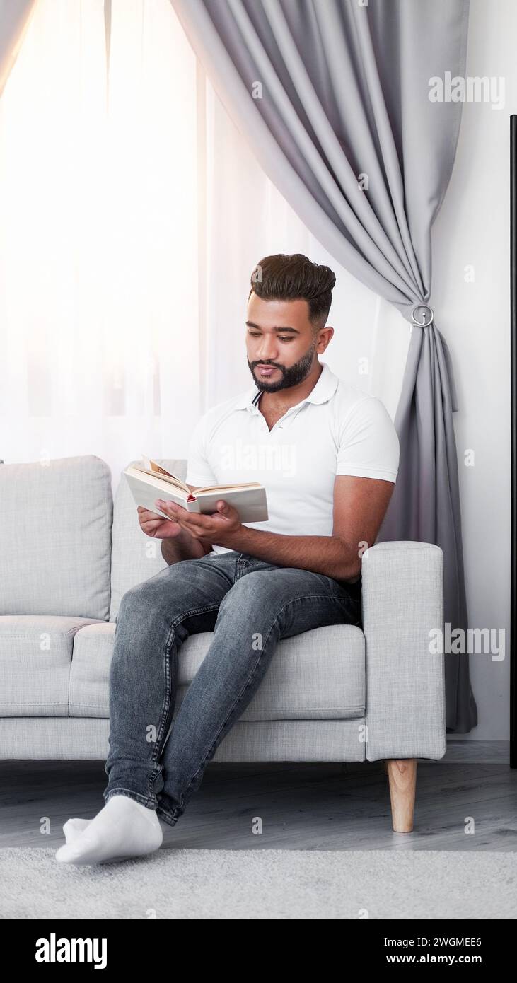 Casa lettura libro relax coinvolto Guy godere romanzo Foto Stock