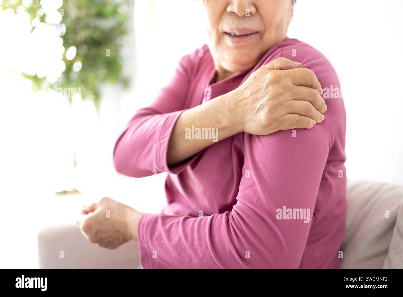 La donna anziana soffre di dolore alle articolazioni della spalla, rigidità della spalla o osteoporosi Foto Stock