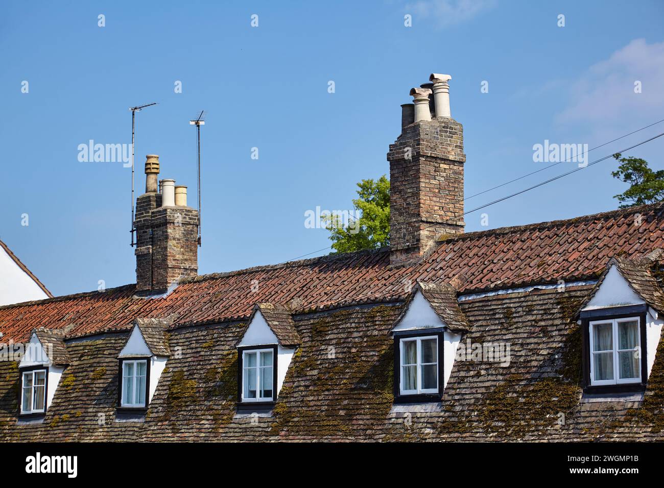 La vista dei tetti di tegole con camini in mattoni di vecchi cottage inglesi nell'Università di Cambridge. Cambridgeshire. Regno Unito Foto Stock