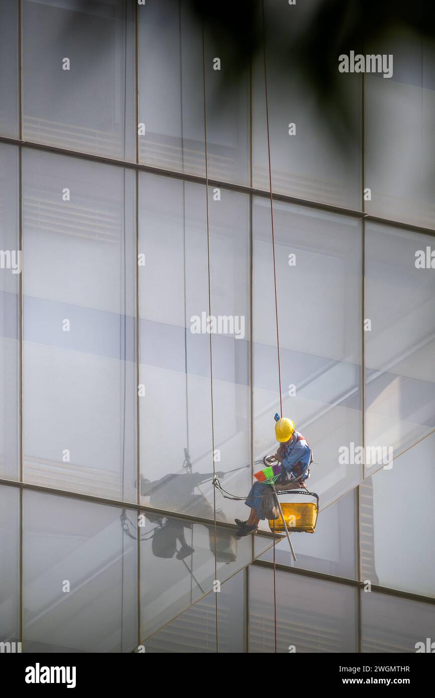 22 gennaio 2024: I lavoratori puliscono il vetro su edifici alti a ho chi Minh City, Vietnam Foto Stock