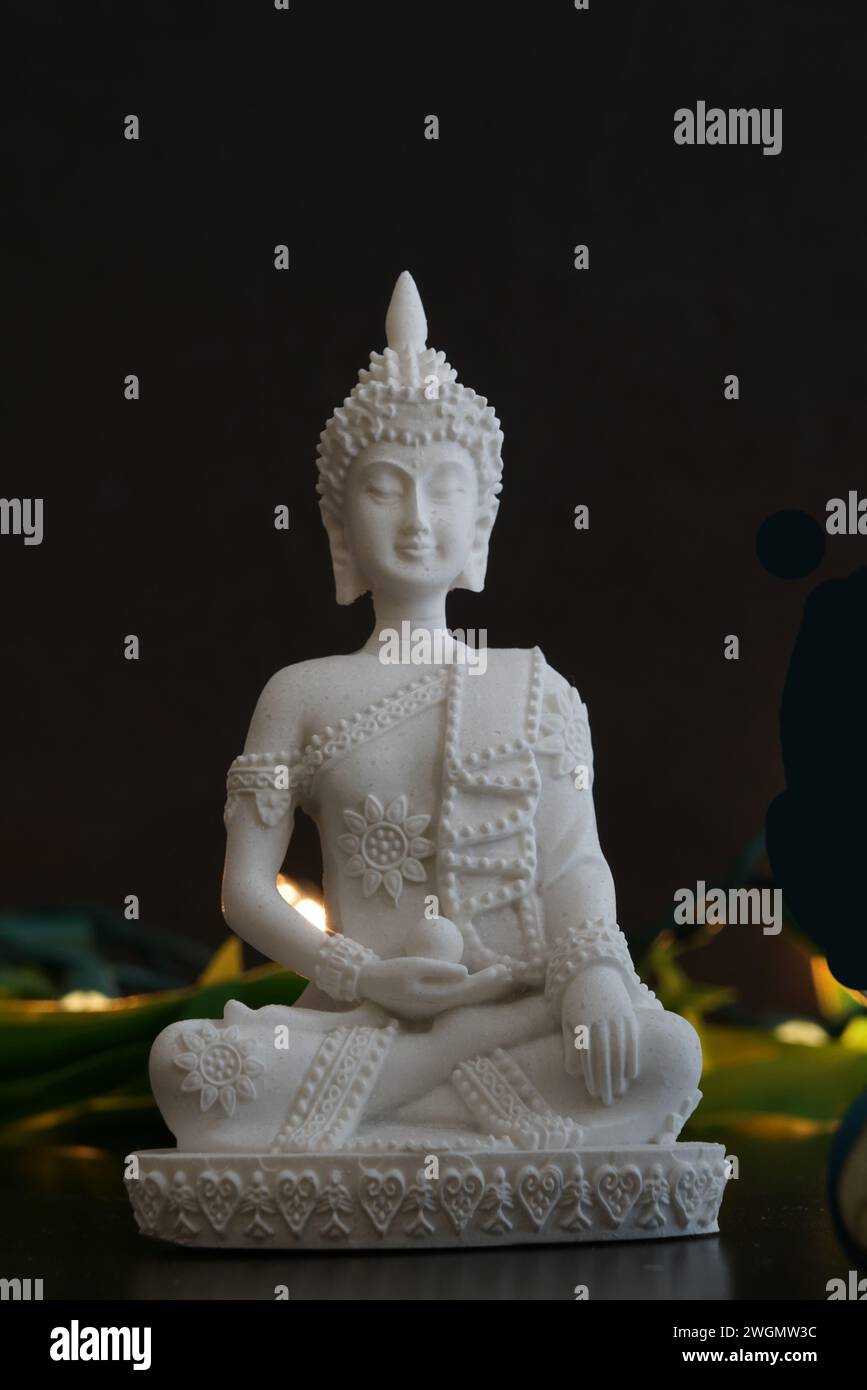 Una statua in arenaria di Buddha su sfondo nero Foto Stock