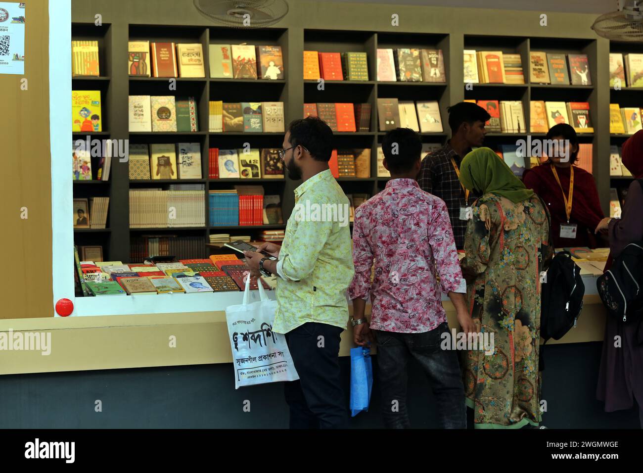 Dhaka, Wari, Bangladesh. 5 febbraio 2024. I visitatori leggono libri alla fiera nazionale del libro chiamata Ekushey Boi Mela a Dacca. Ogni anno, la Bangla Academy organizza la fiera nazionale del libro nell'area dell'Università di Dhaka. Questa fiera del libro è la più grande del Bangladesh e si svolge per tutto il mese di febbraio. Dacca, Bangladesh, 6 febbraio 2024. (Credit Image: © Habibur Rahman/ZUMA Press Wire) SOLO PER USO EDITORIALE! Non per USO commerciale! Foto Stock