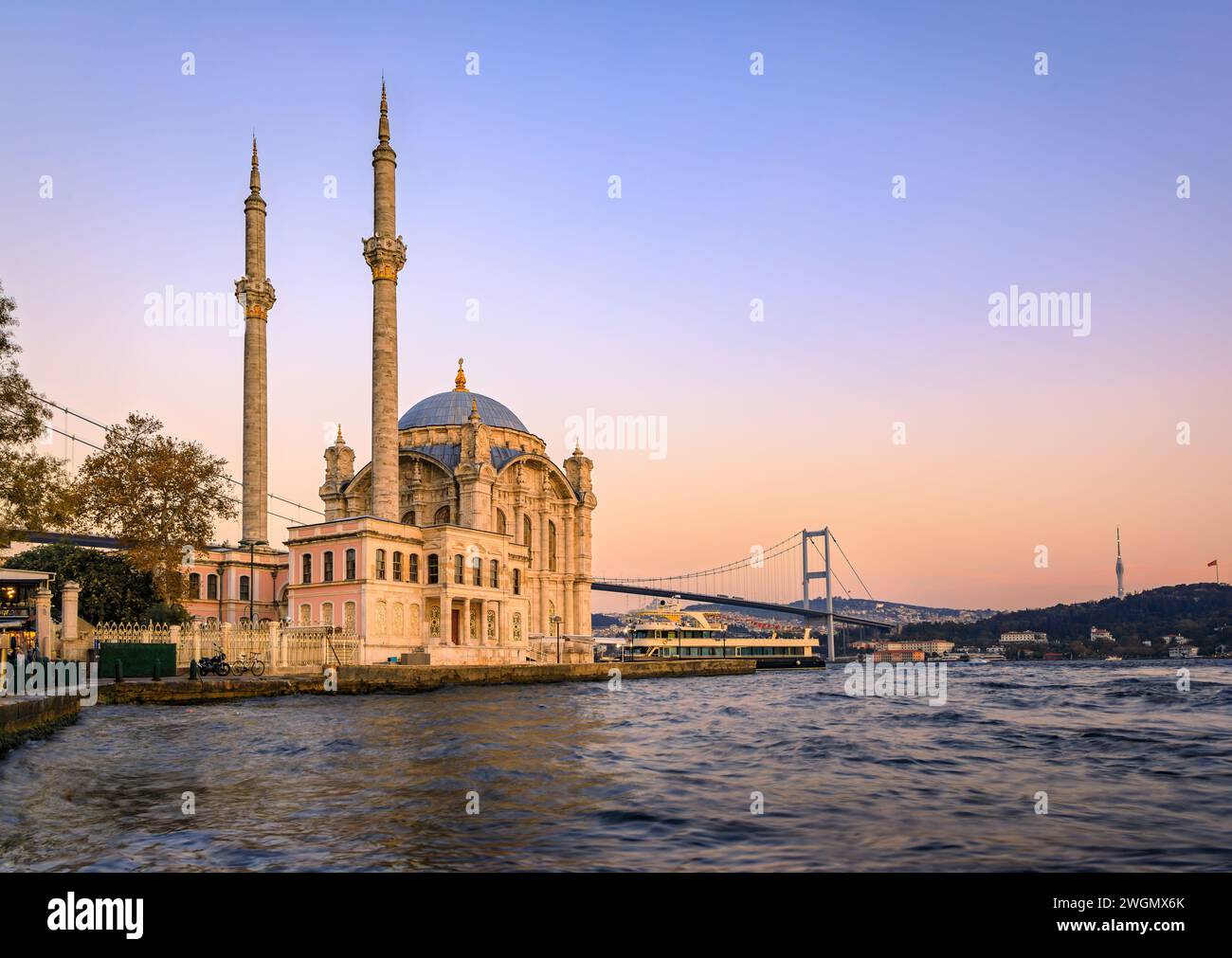 Pittoresco paesaggio urbano con lo stretto del Bosforo e la grande Moschea Mecidiye Moschea Ortakoy e il Ponte sul Bosforo di Istanbul, Turchia al tramonto Foto Stock