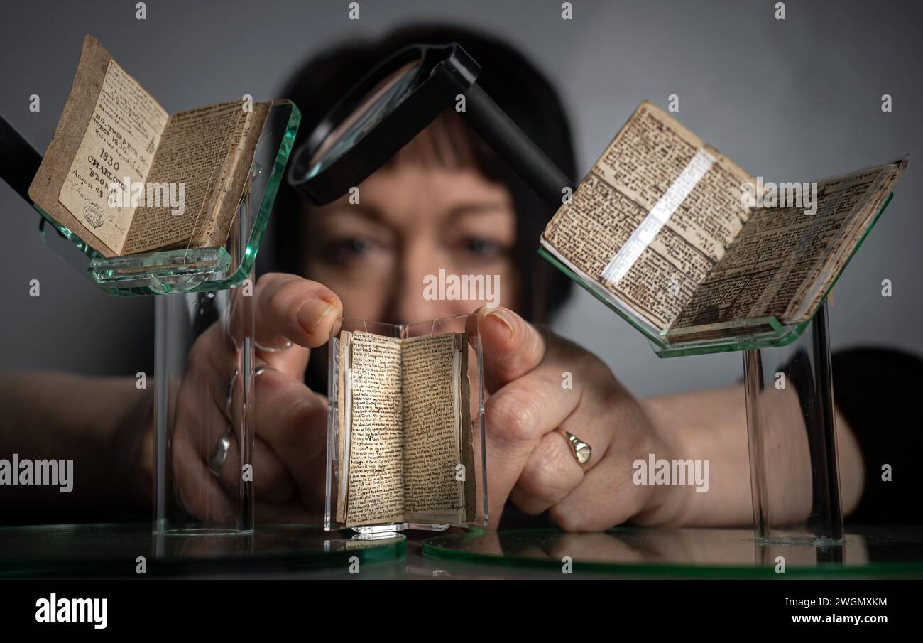 Curatrice principale Ann Dinsdale, con alcuni dei "piccoli libri" scritti da Charlotte e Branwell Bronte, alla mostra Web of Childhood dei Brontes, al Bronte Parsonage Museum di Haworth, West Yorkshire. Gli anni formativi di una delle famiglie più famose della letteratura sono al centro di un nuovo programma di mostre, discorsi e attività presso il museo nel 2024, in un'esplorazione di come l'infanzia di Branwell, Charlotte, Emily e Anne Bronte le hanno plasmate come scrittori. Data foto: Lunedì 5 febbraio 2024. Foto Stock