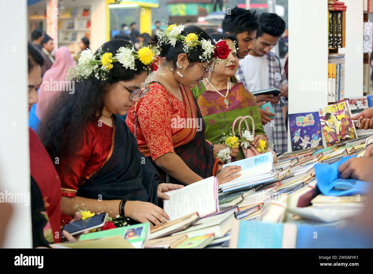 Dacca, Bangladesh. 6 febbraio 2024. I visitatori leggono libri alla fiera nazionale del libro chiamata Ekushey Boi Mela a Dacca. Ogni anno, la Bangla Academy organizza la fiera nazionale del libro nell'area dell'Università di Dhaka. Questa fiera del libro è la più grande del Bangladesh e si svolge per tutto il mese di febbraio. Dacca, Bangladesh, 6 febbraio 2024. Foto di Habibur Rahman/ABACAPRESS.COM credito: Abaca Press/Alamy Live News Foto Stock