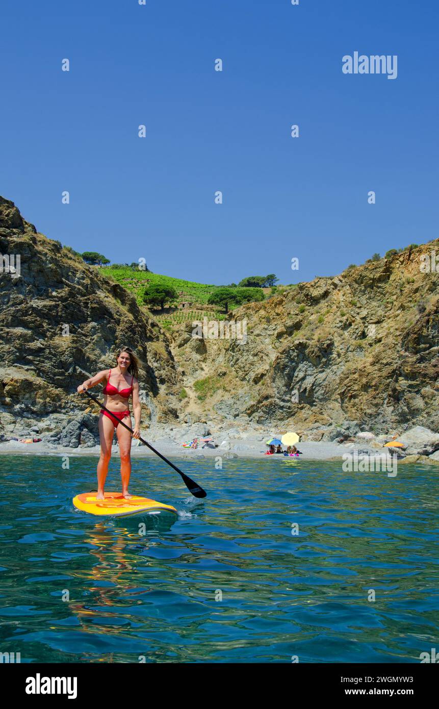 capelli biondi bella giovane e attraente donna che fa standup paddle sull'acqua di mare Foto Stock