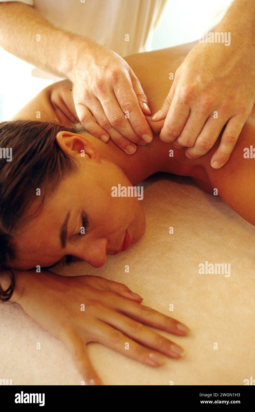 bella auburn capelli, giovane donna sul retro, viso, lettino massaggiante spa naturale con mani di terapeuta, luce soffusa e rilassante Foto Stock