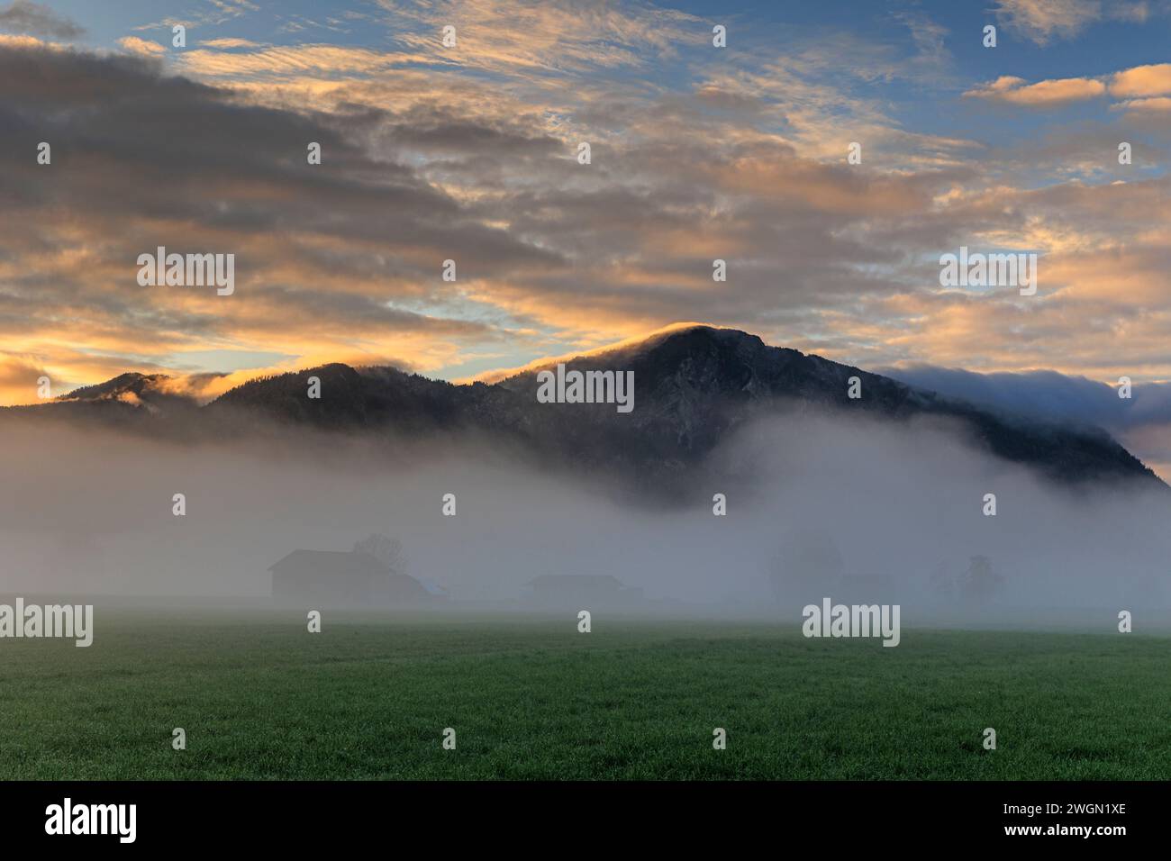 Vecchia capanna di legno all'alba di fronte alle montagne, nebbia, estate, Loisach-Kochelsee-Moor, Baviera, Germania, Europa Foto Stock