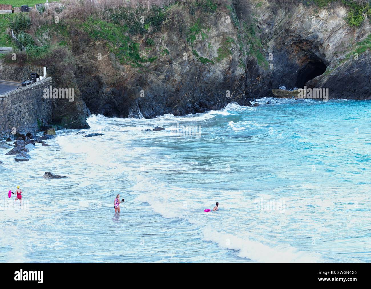 Tre nuotatrici nell'Oceano Atlantico a Towan Beach, Newquay, Cornovaglia, Inghilterra, in un giorno d'inverno. Foto Stock