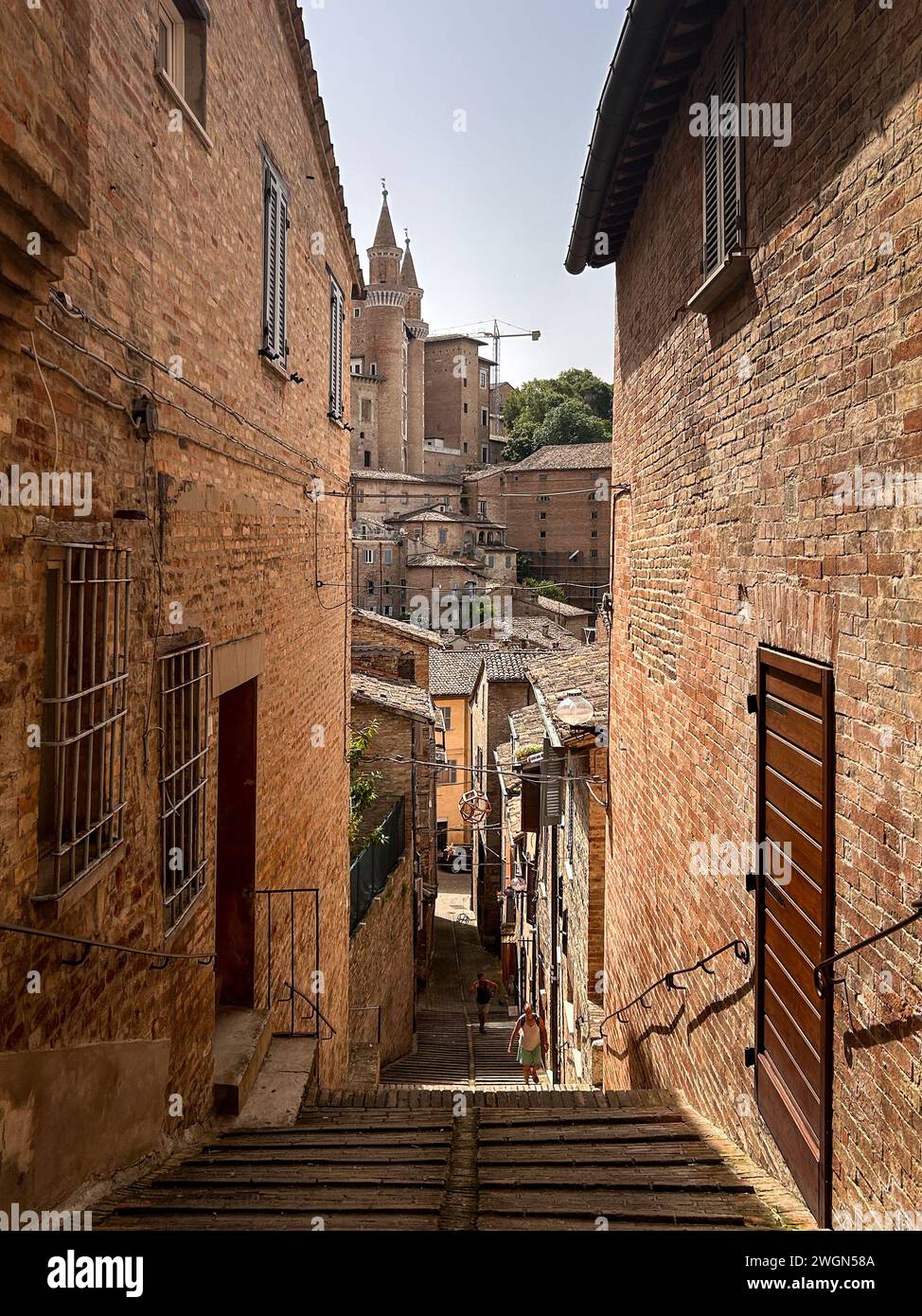 Passo dopo passo, l'antica scalinata in pietra conduce alle incantevoli strade di Urbino, invitando all'esplorazione e alla scoperta. Foto Stock