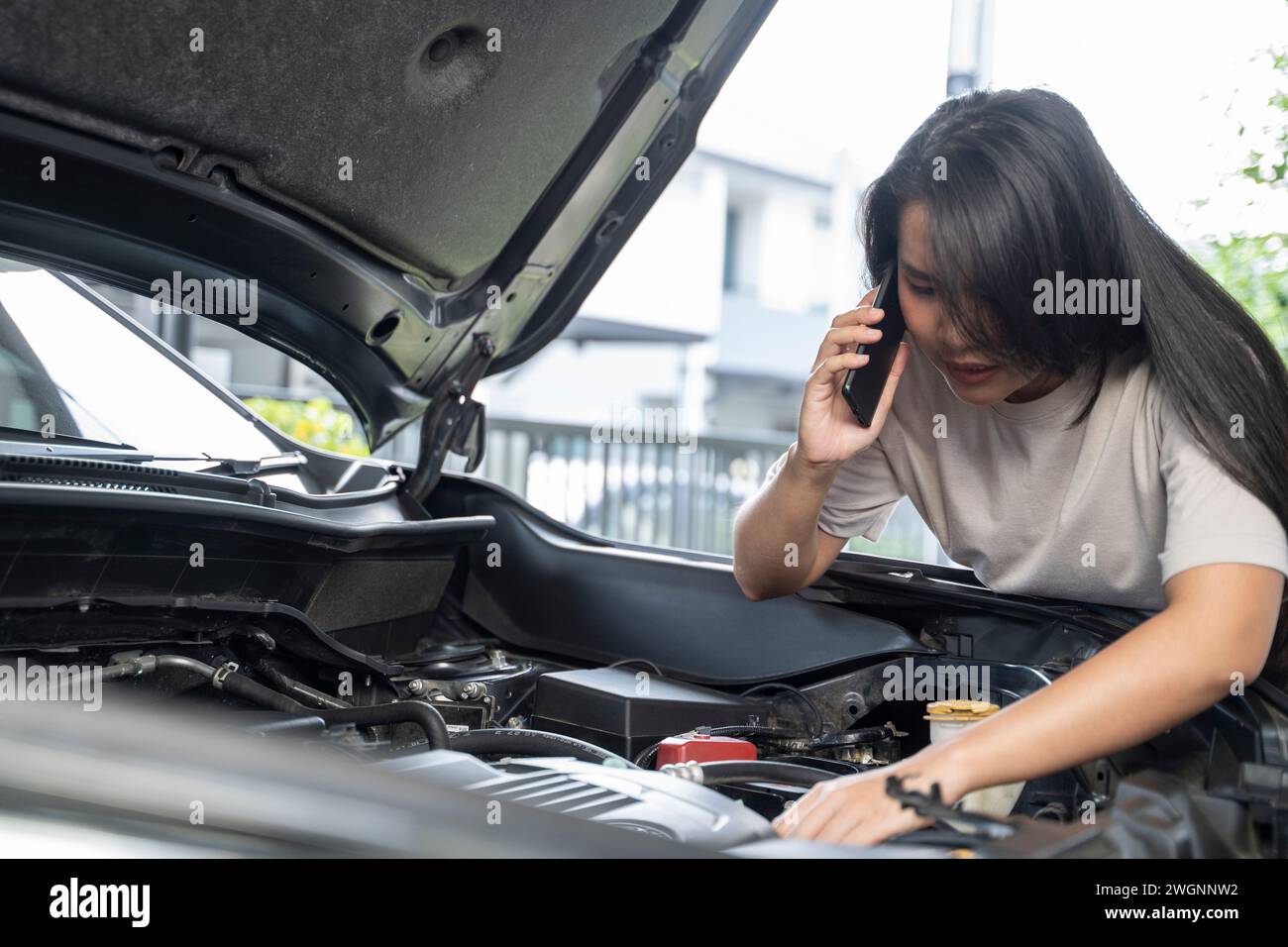 Hai bisogno di aiuto con il guasto dell'auto donna seria ascolta i consigli e la spiegazione del servizio di riparazione auto di emergenza al telefono. Foto Stock