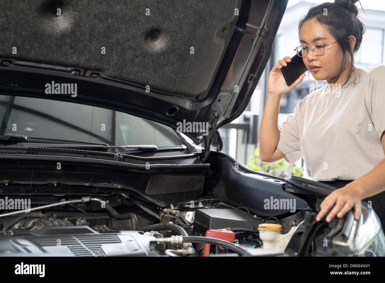 Hai bisogno di aiuto con il guasto dell'auto donna seria ascolta i consigli e la spiegazione del servizio di riparazione auto di emergenza al telefono. Foto Stock