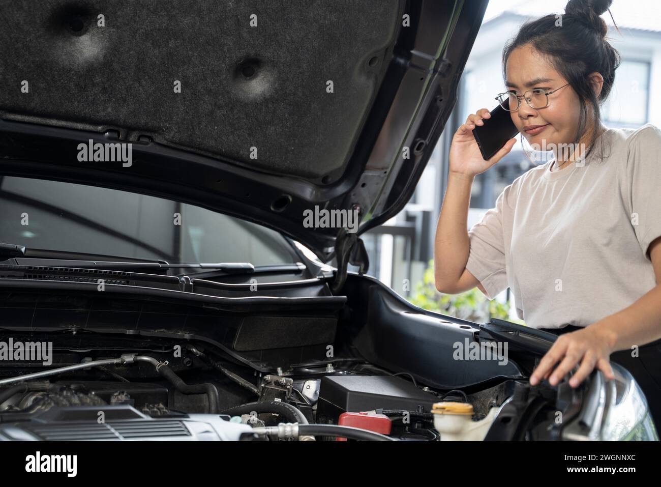 Hai bisogno di aiuto con il guasto dell'auto donna seria ascolta i consigli e la spiegazione del servizio di riparazione auto di emergenza al telefono. Foto Stock