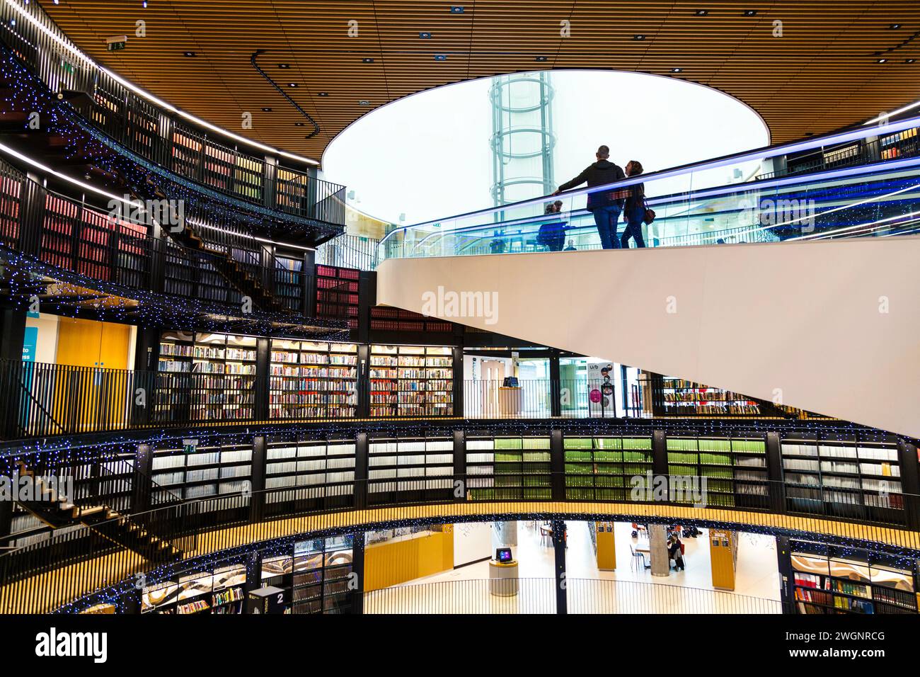 Persone che viaggiano con un viaggiatore all'interno della Biblioteca di Birmingham, Birmingham, Inghilterra Foto Stock