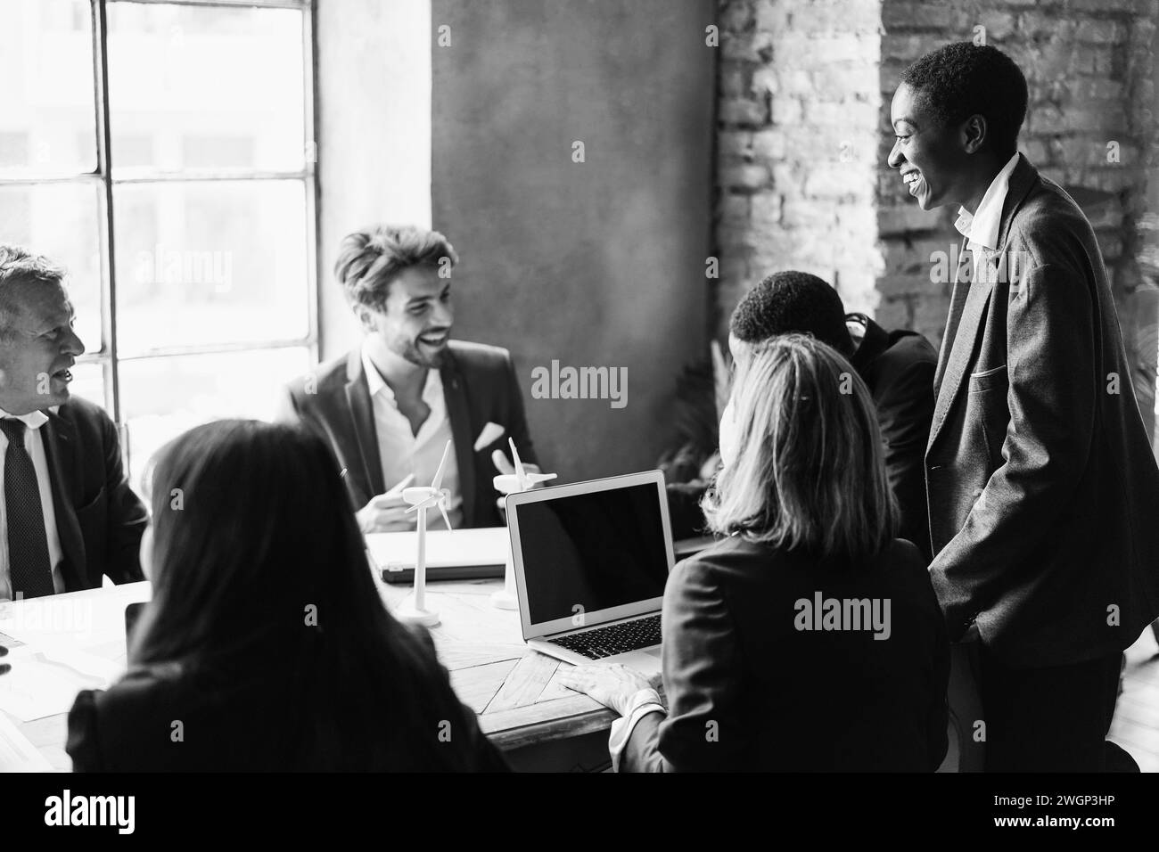 Uomini d'affari multirazziali che lavorano su un progetto di innovazione sostenibile - concetto di energia rinnovabile verde - Focus on african Woman Face - bianco e nero Foto Stock