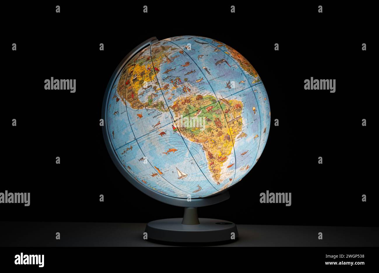 Globo terrestre illuminato sotto forma di luce da scrivania o da tavolo, che si illumina al buio, senza persone. Foto Stock