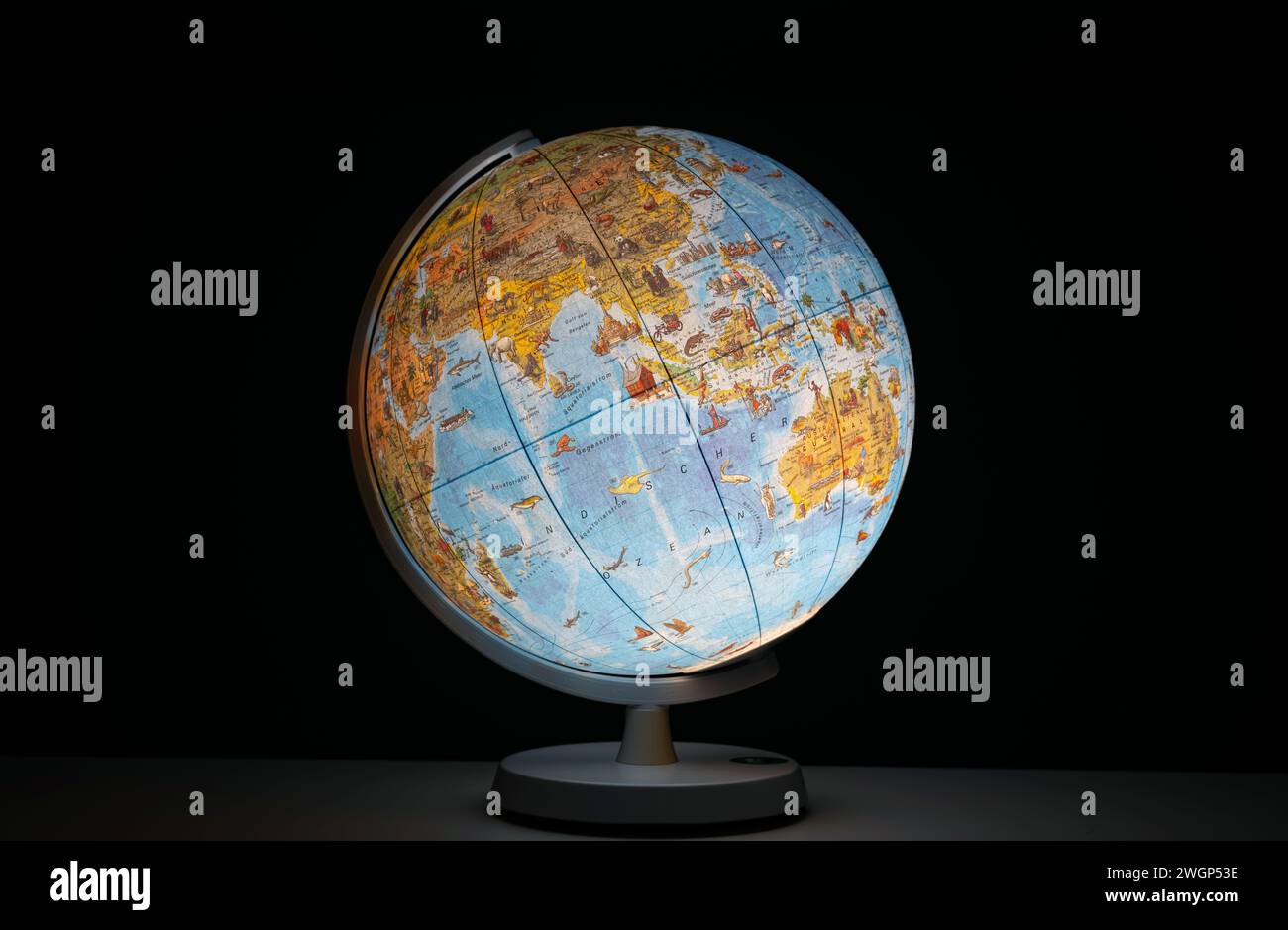 Globo terrestre illuminato sotto forma di luce da scrivania o da tavolo, che si illumina al buio, senza persone. Foto Stock