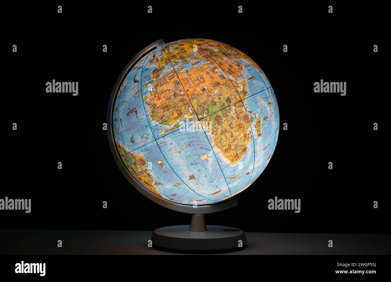 Globo terrestre illuminato sotto forma di luce da scrivania o da tavolo, che si illumina al buio, senza persone. Foto Stock
