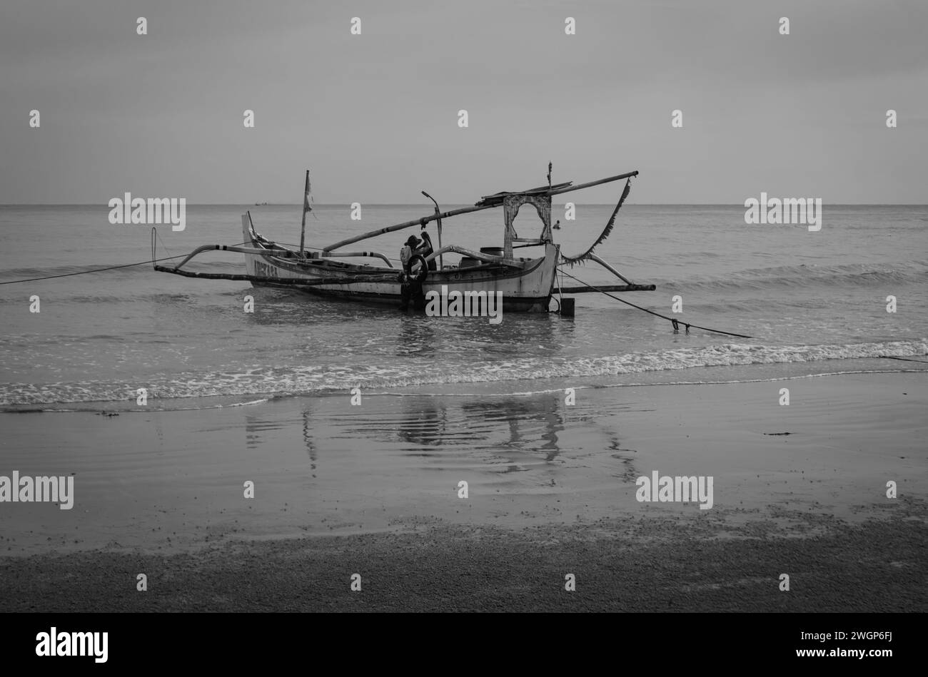I pescatori asiatici si preparano a lavorare sulle tradizionali barche da pesca galleggianti sulla costa di Sumenep, isola di Madura, Indonesia. Foto Stock