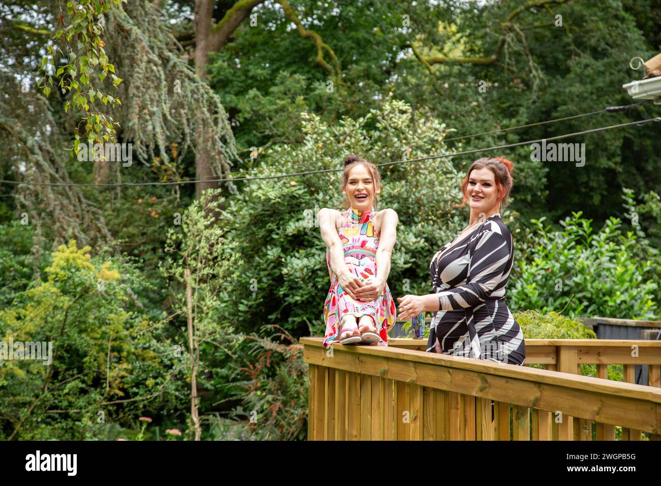 Due giovani Trans donne che si divertono e si godono una festa estiva in giardino Foto Stock