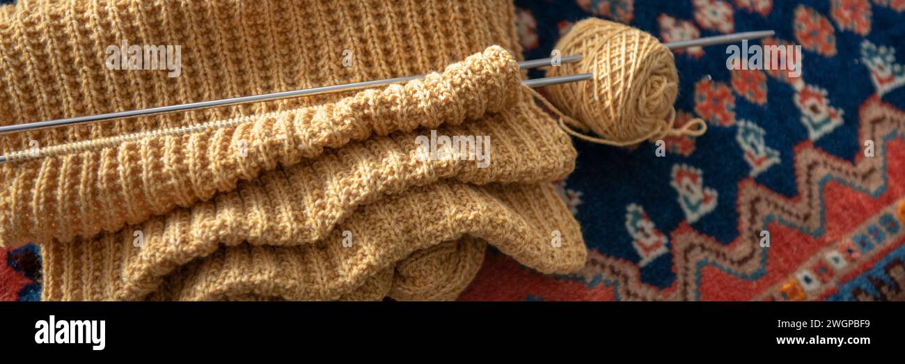 Primo piano di una signora Elderley che lavora a maglia al suo tavolo da pranzo Foto Stock