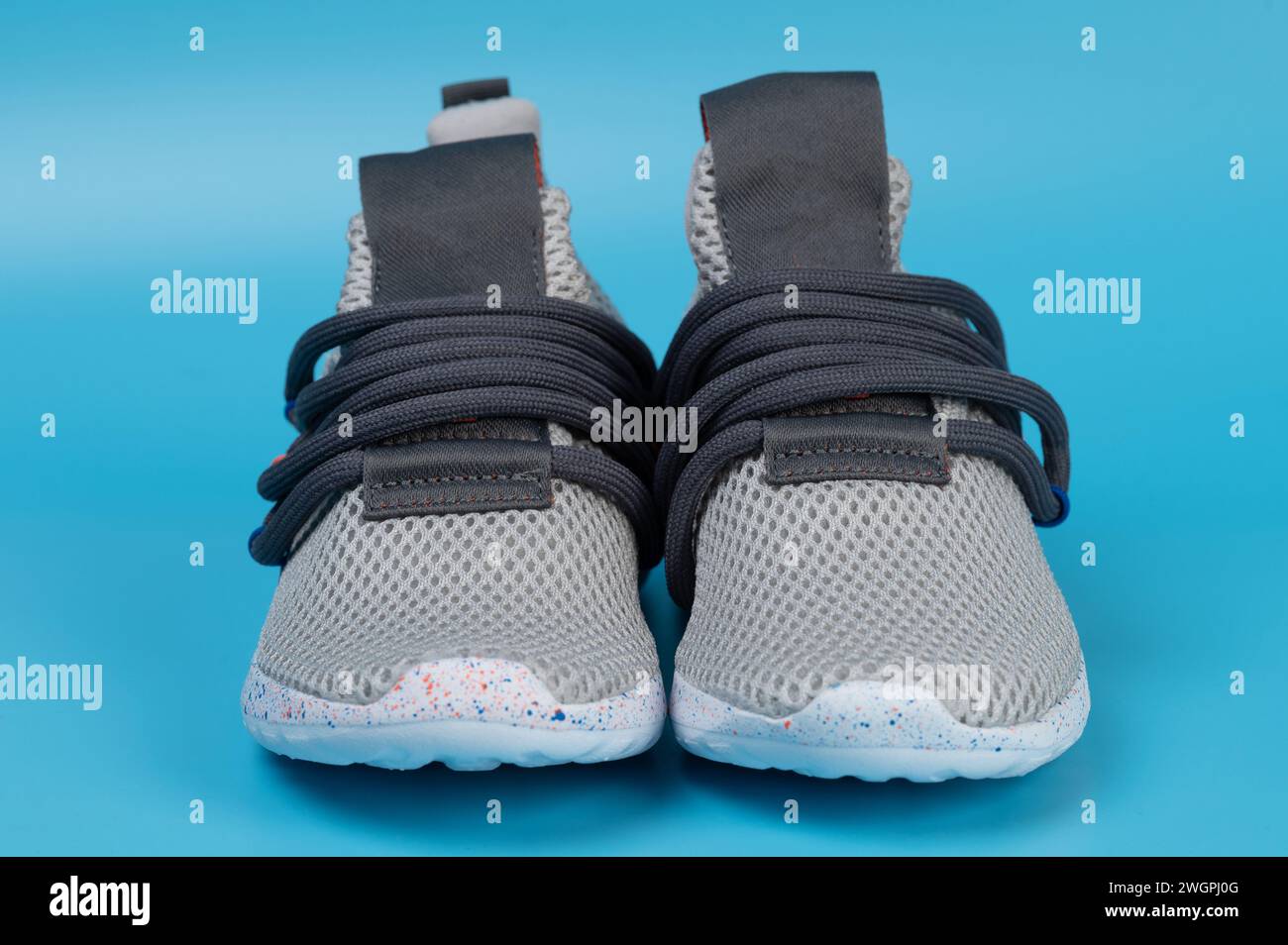 Scarpe per bambini grigie senza lacci su sfondo blu studio vista ravvicinata Foto Stock