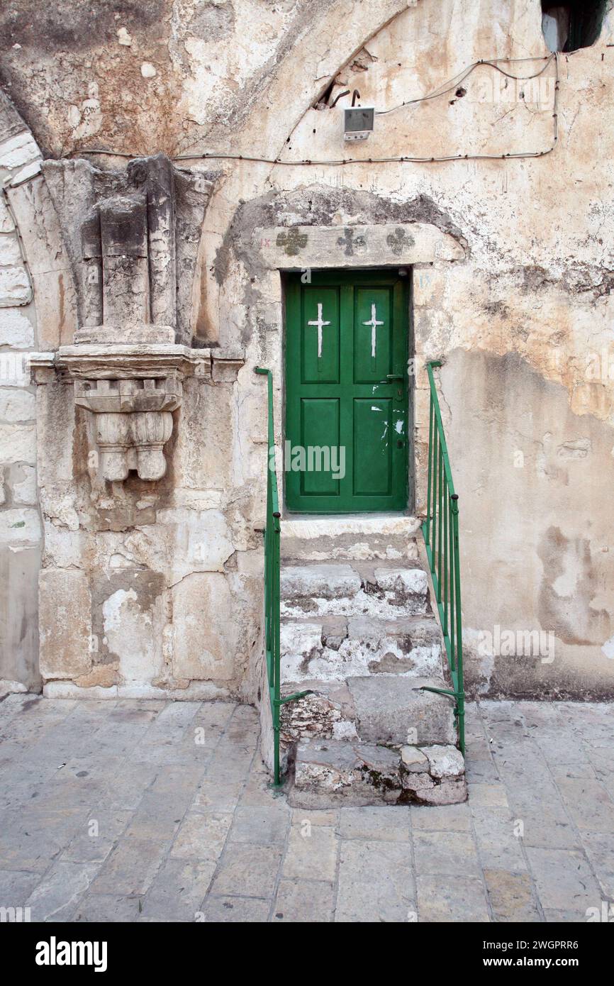 Il tetto della Chiesa del Santo Sepolcro è dotato di gradini dettagliati per la porta verde con corrimano in legno e croce, Gerusalemme, Israele Foto Stock