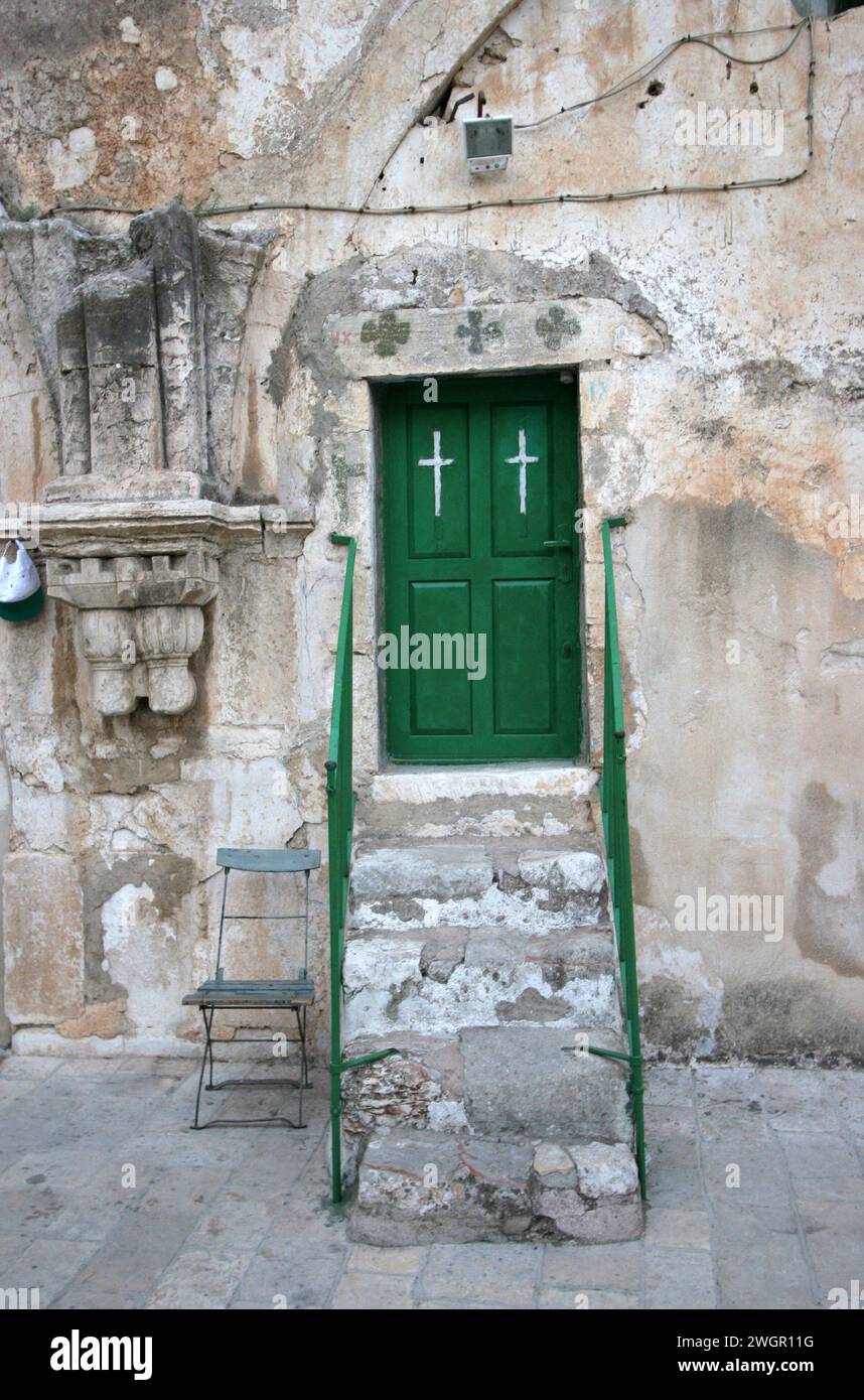 Il tetto della Chiesa del Santo Sepolcro è dotato di gradini dettagliati per la porta verde con corrimano in legno e croce, Gerusalemme, Israele Foto Stock