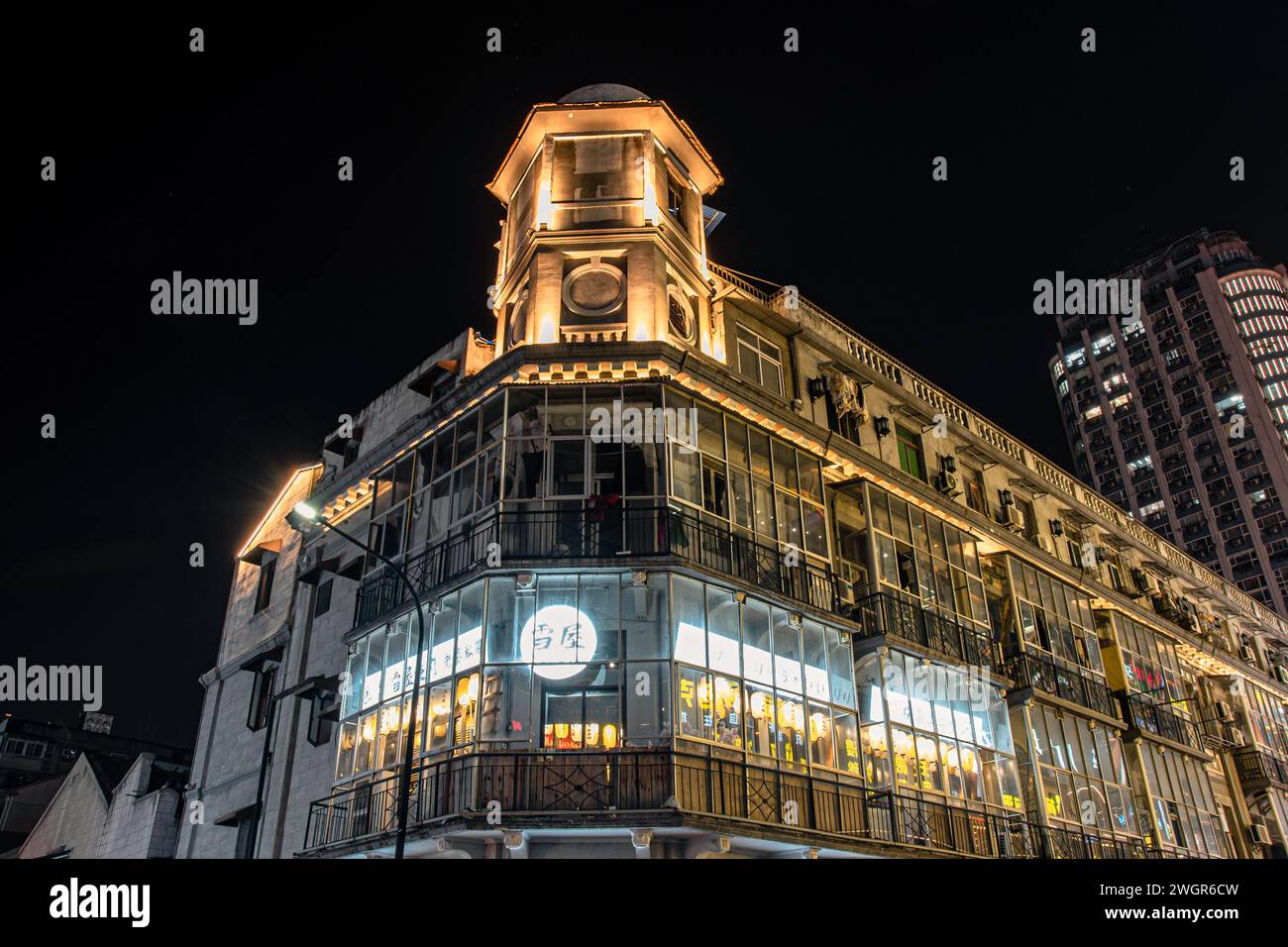 Vista notturna illuminata di un elegante edificio adornato da luci vibranti Foto Stock