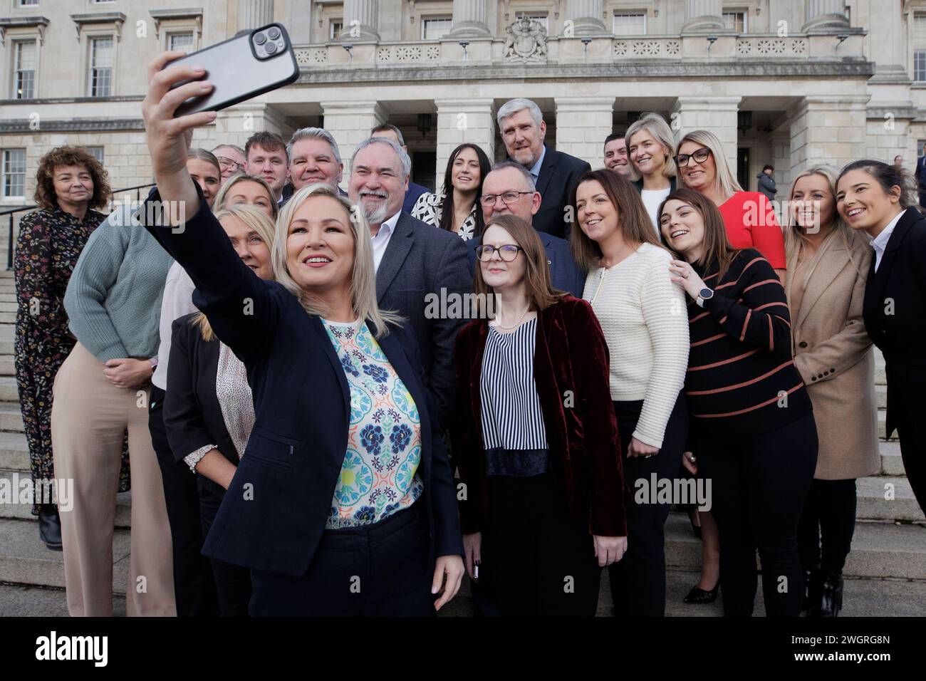 Il primo ministro dell'Irlanda del Nord Michelle o'Neill scatta una foto con i suoi colleghi del partito Sinn Fein MLA sui gradini degli edifici del Parlamento a Stormont. Data foto: Martedì 6 febbraio 2024. Foto Stock