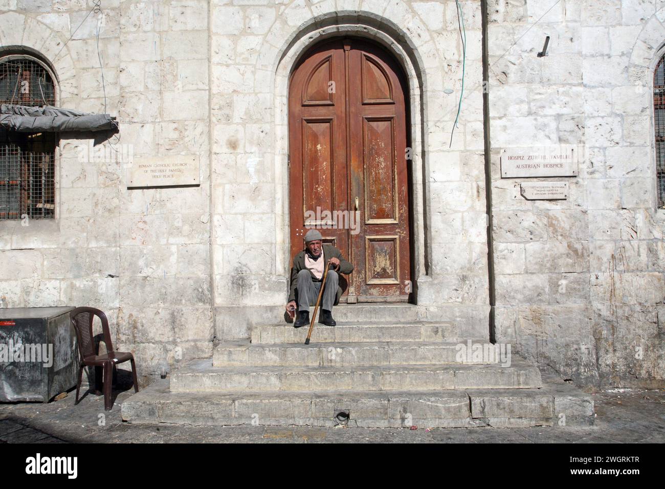 Un uomo siede all'ingresso dell'Ospizio austriaco della Sacra famiglia a Gerusalemme, Israele Foto Stock