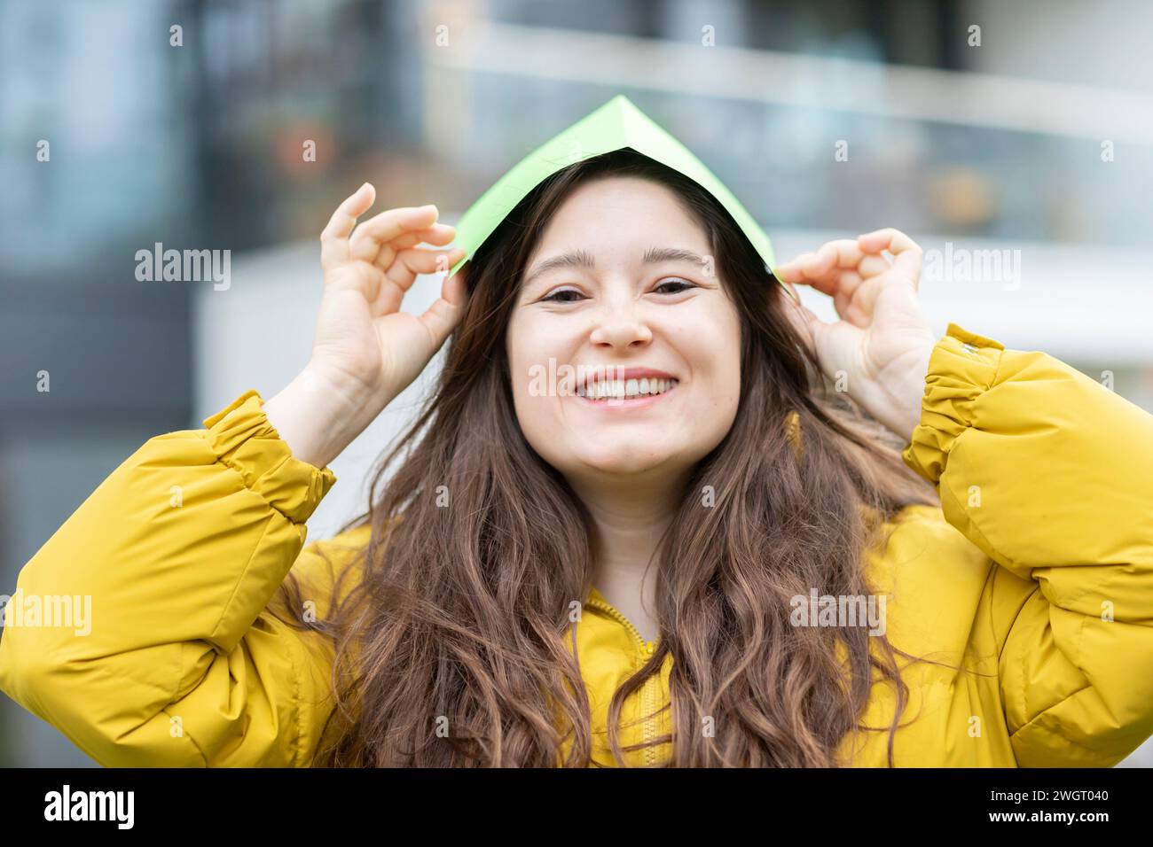 giovane donna con tetto in carta verde come protezione del clima all'esterno Foto Stock