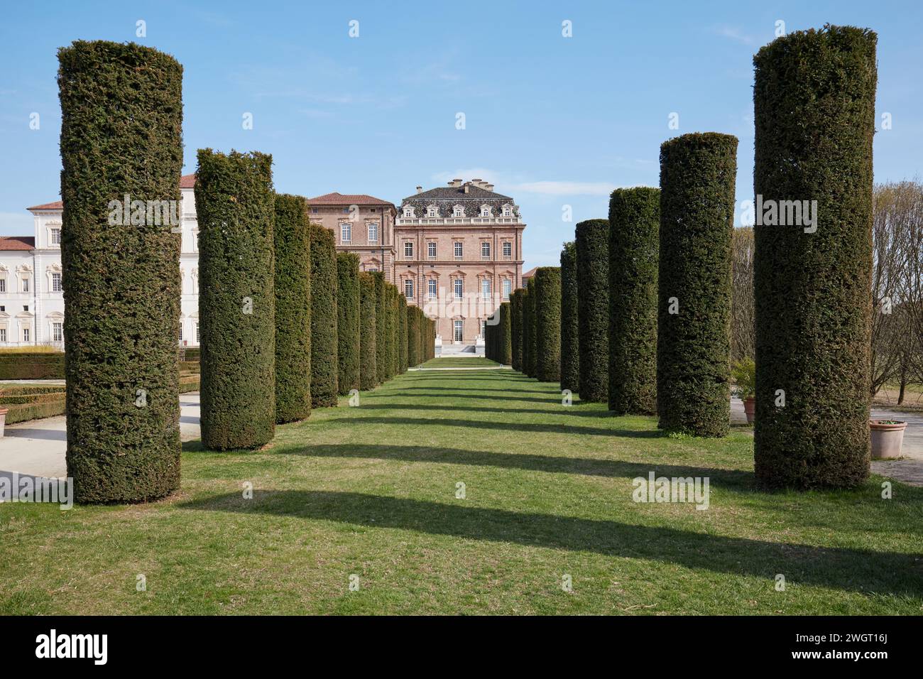 VENARIA REALE, ITALIA - 29 MARZO 2023: Parco del castello della Reggia di Venaria con siepi cilindriche, vista simmetrica alla luce del sole primaverile Foto Stock