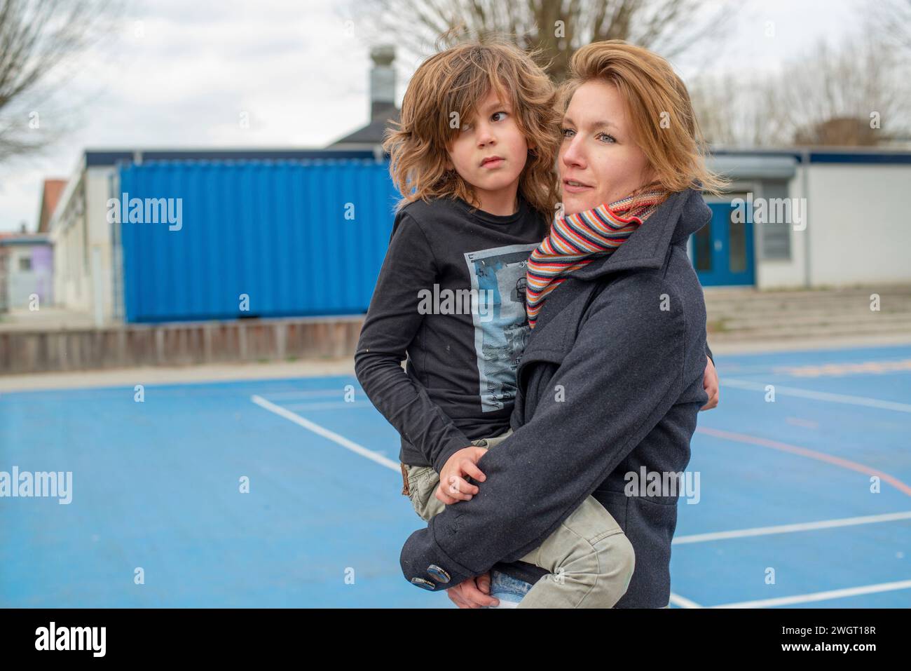 Giovane ragazzo con sua madre che si abbraccia dopo essere caduto e essersi fatto del male. rapporto sano Foto Stock
