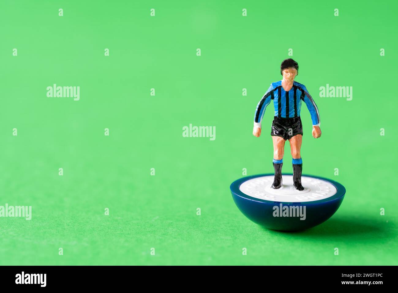 Un'unica figura in miniatura Subbuteo dipinta nei colori della squadra di casa dell'Inter Milan con maglie a righe blu e nere e pantaloncini neri Foto Stock