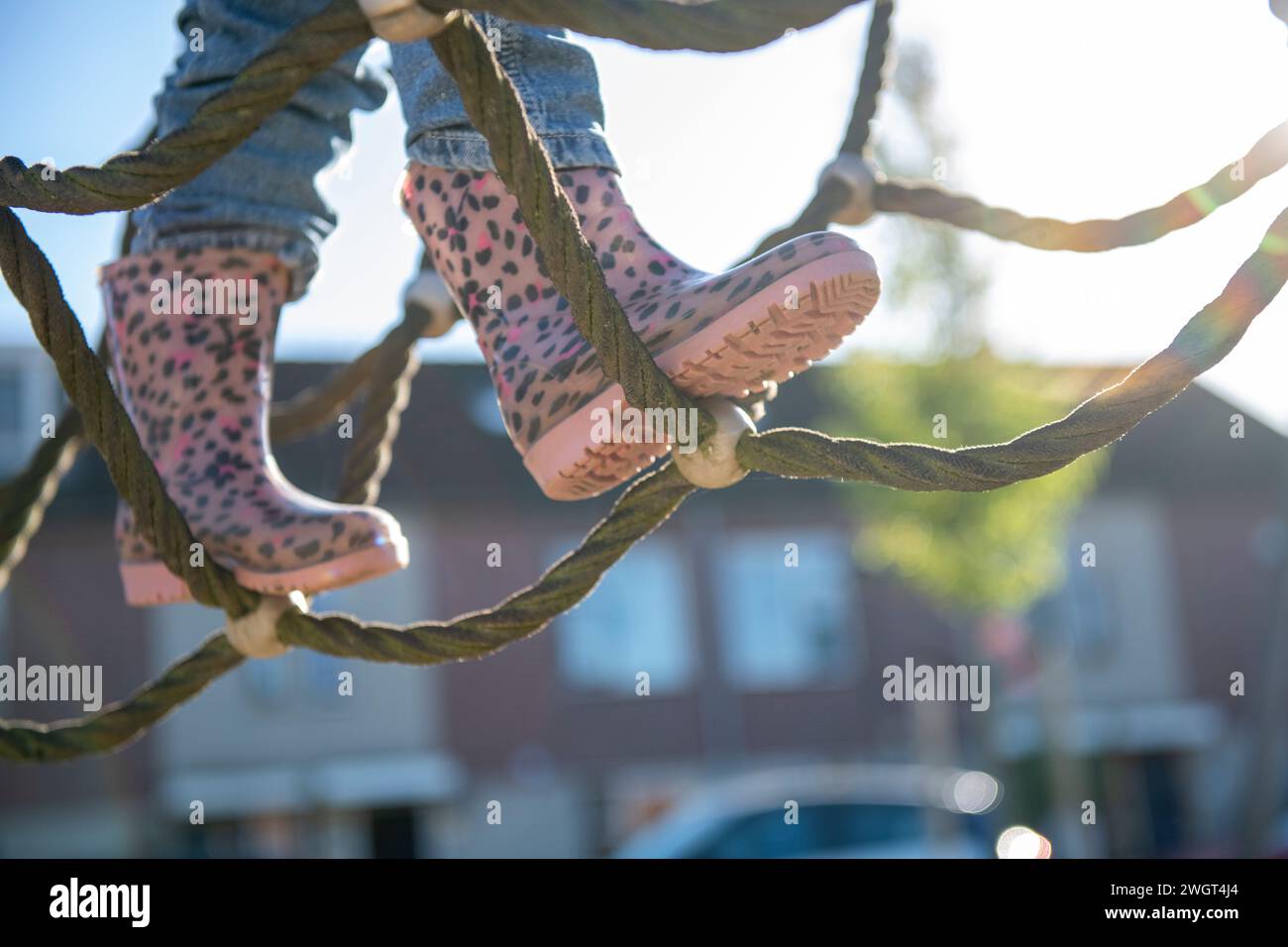La bambina è coraggiosa ad arrampicarsi in un parco avventura nel parco pubblico Foto Stock