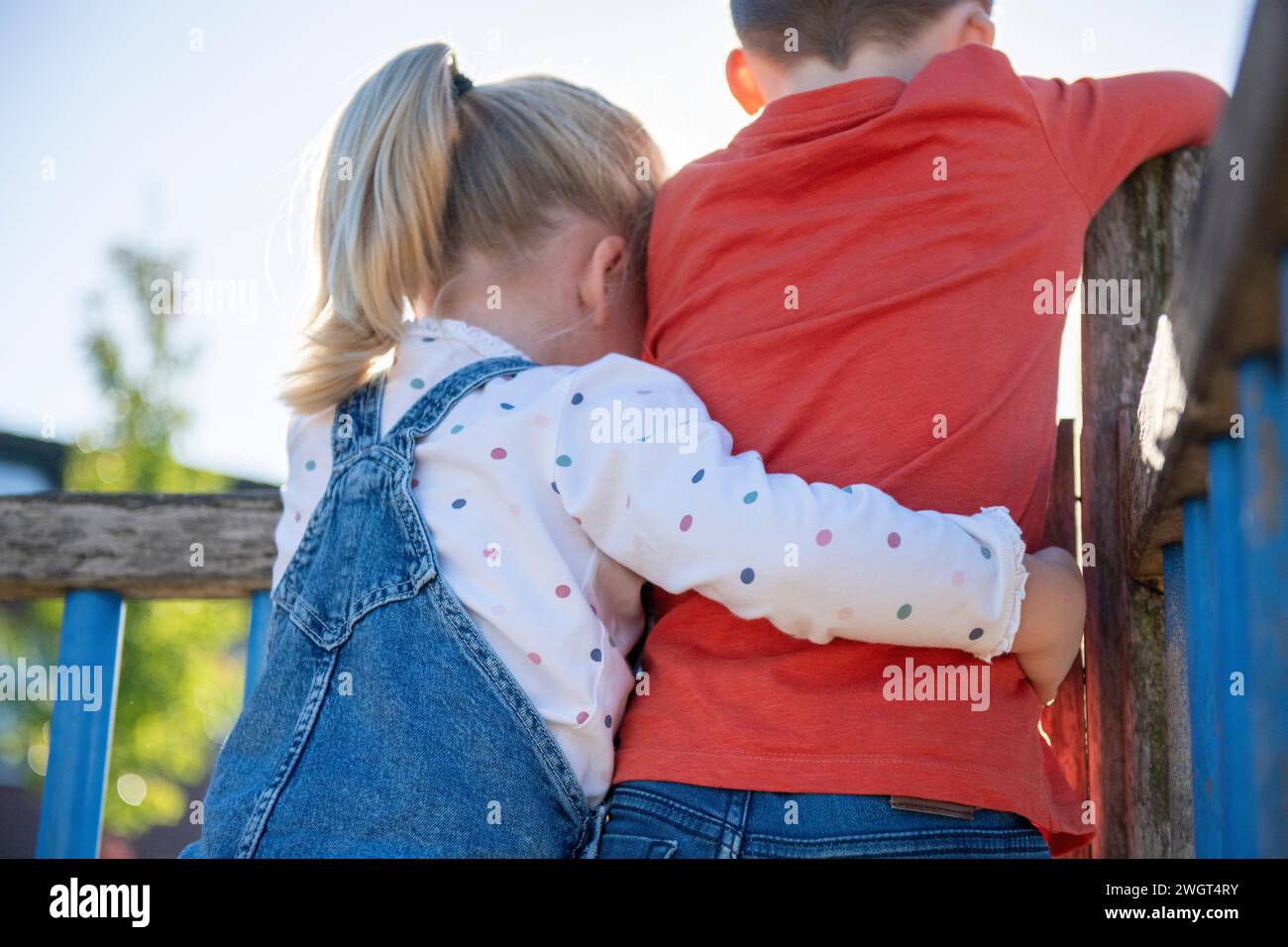 Fratello e sorella abbracciano e legano in un parco pubblico. Sorella che abbraccia suo fratello Foto Stock