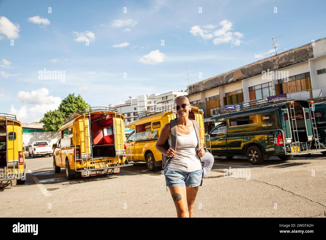 Donna di mezza età, viaggiatore solo si trova in una stazione degli autobus nel nord della Thailandia Foto Stock