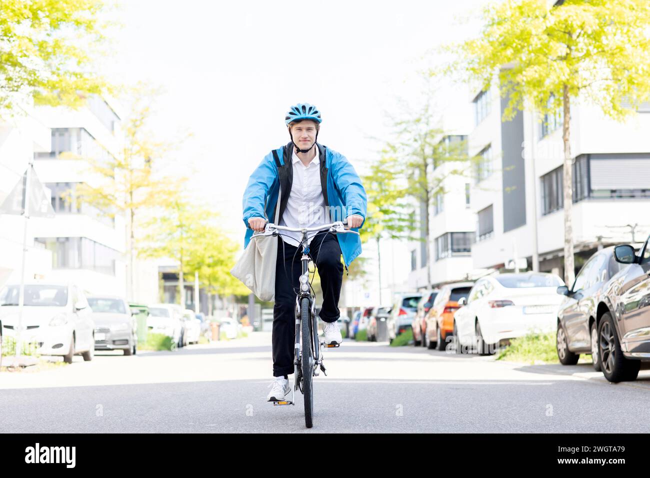 Giovane in bicicletta in città con il casco Foto Stock