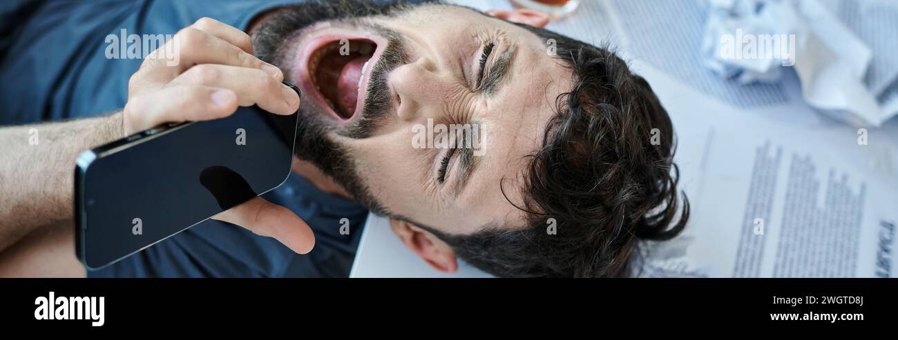 uomo frustrato che urla al telefono con un bicchiere di alcol accanto a lui durante il crollo mentale, striscione Foto Stock