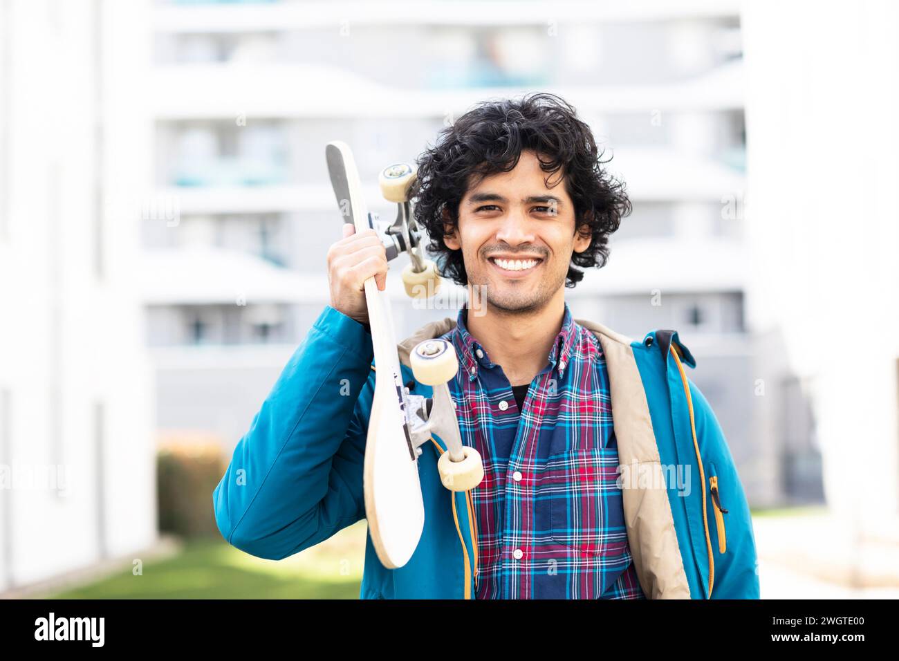 giovane con skateboard che trasporta fuori Foto Stock